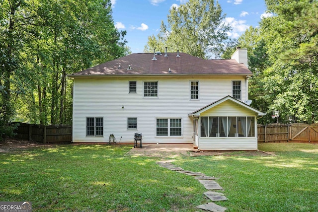 back of house with a lawn and a sunroom