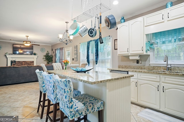 kitchen with a kitchen bar, crown molding, a center island, and white cabinets