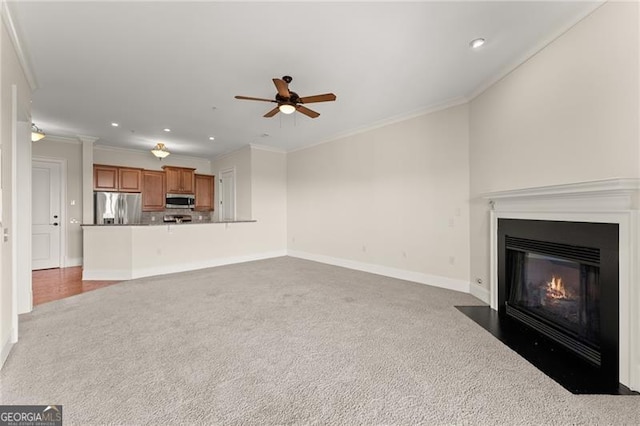 unfurnished living room with ceiling fan, light colored carpet, and ornamental molding