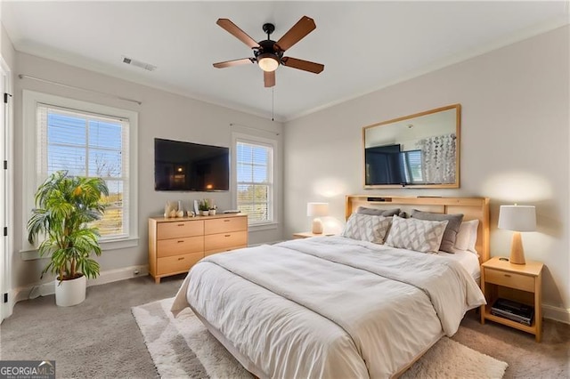 carpeted bedroom with ceiling fan and ornamental molding