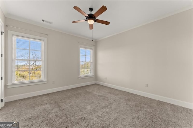 carpeted spare room featuring crown molding and ceiling fan