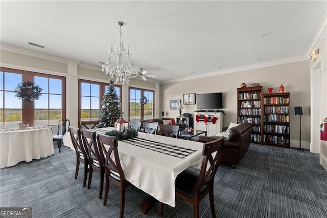 carpeted dining space featuring crown molding and a chandelier