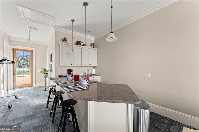 351 Washington Ave NE Ste 302, Marietta, GA 30060 - kitchen featuring a breakfast bar, dark carpet, crown molding, and white cabinets