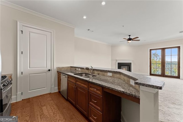 kitchen featuring sink, crown molding, stainless steel appliances, stone countertops, and kitchen peninsula