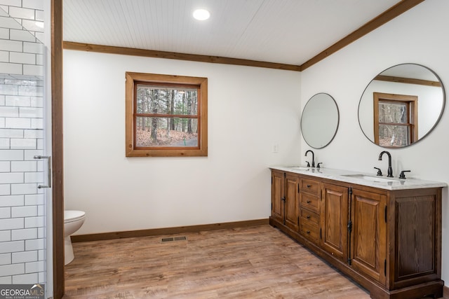 bathroom with hardwood / wood-style flooring, vanity, toilet, and ornamental molding