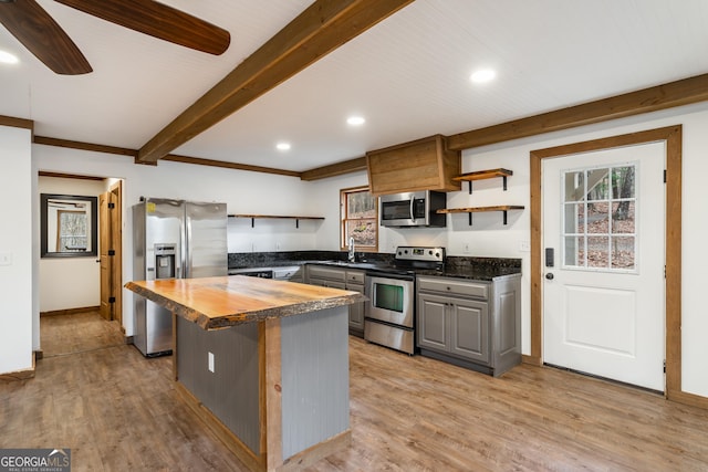 kitchen featuring gray cabinetry, ceiling fan, a center island, stainless steel appliances, and butcher block countertops