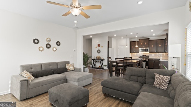 living room with light hardwood / wood-style floors, plenty of natural light, and ceiling fan