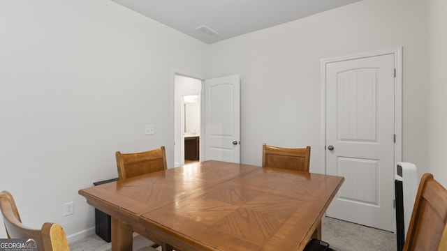 dining area featuring light carpet