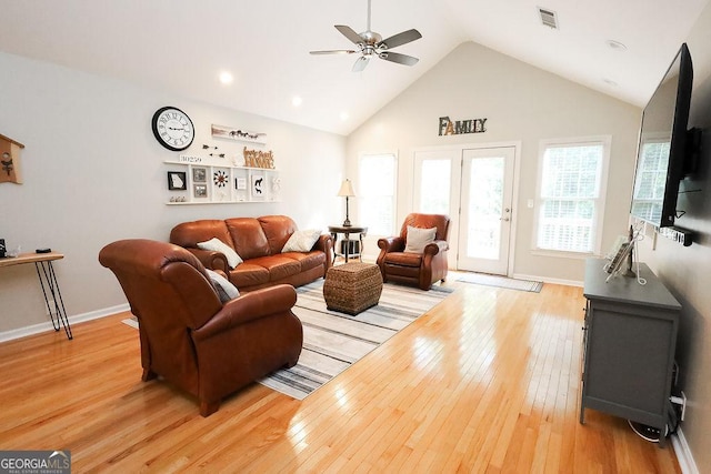 living room featuring light hardwood / wood-style flooring, high vaulted ceiling, and ceiling fan