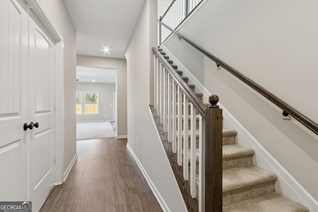 stairway featuring recessed lighting, baseboards, and wood finished floors