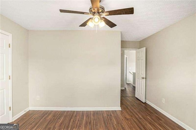 unfurnished room featuring a textured ceiling and dark hardwood / wood-style floors