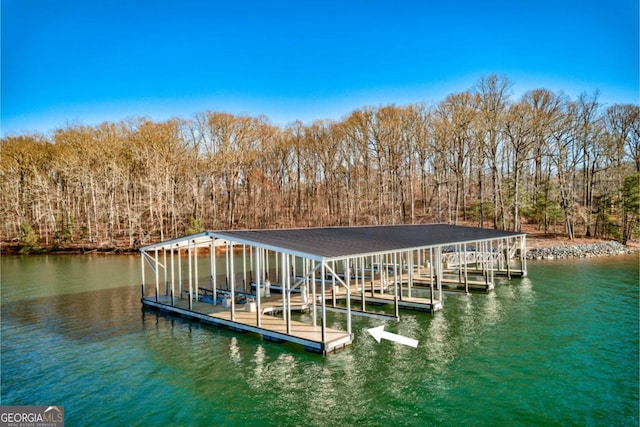 dock area featuring boat lift, a water view, and a wooded view