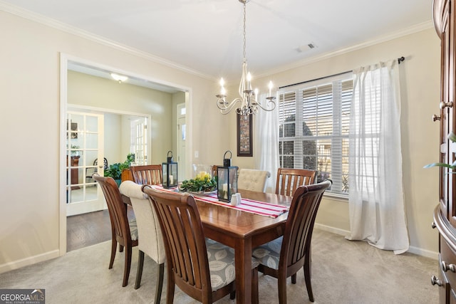 carpeted dining room featuring an inviting chandelier and crown molding