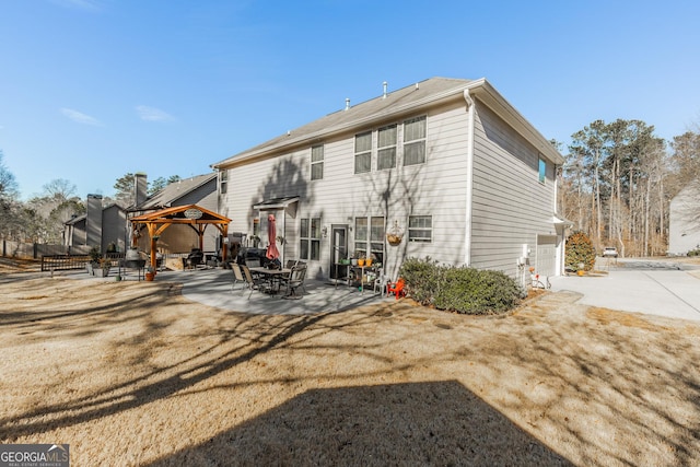 back of house with a garage, a gazebo, a patio, and a yard