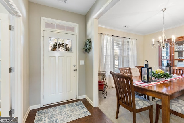 foyer with a chandelier, a wealth of natural light, and dark hardwood / wood-style flooring