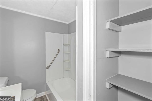 bathroom featuring shower / bathing tub combination, wood-type flooring, and toilet