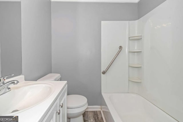 full bathroom with shower / bathing tub combination, vanity, hardwood / wood-style flooring, and toilet