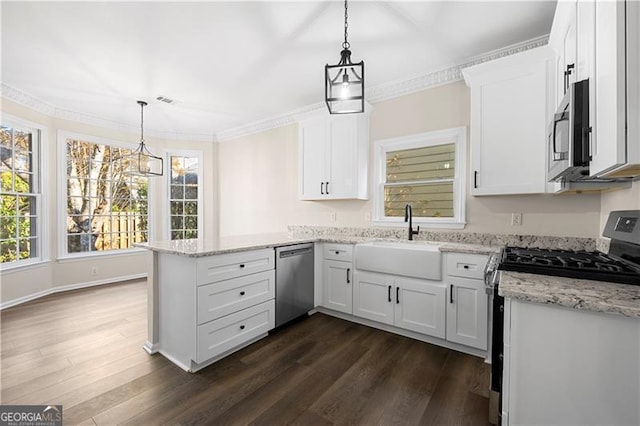 kitchen with kitchen peninsula, white cabinets, decorative light fixtures, and appliances with stainless steel finishes