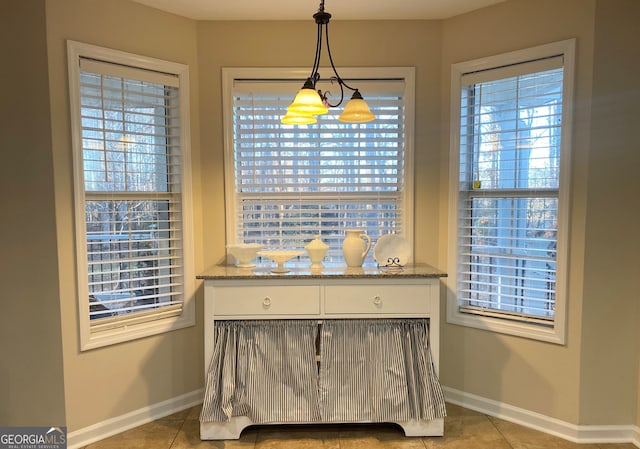 interior space featuring light tile patterned floors and a chandelier