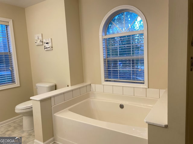 bathroom with a washtub and toilet