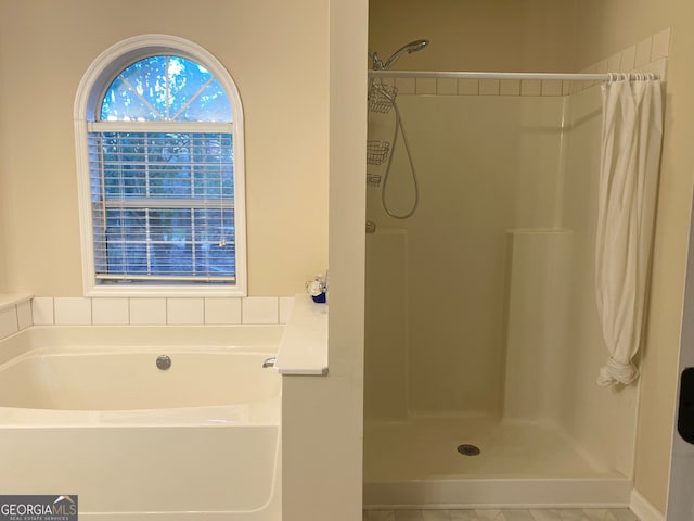 bathroom featuring independent shower and bath