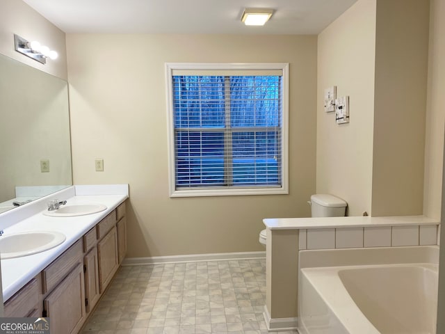 bathroom featuring vanity, toilet, and a tub