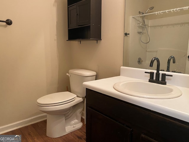 bathroom with vanity, hardwood / wood-style flooring, toilet, and walk in shower