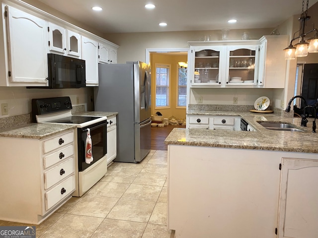 kitchen with kitchen peninsula, sink, electric stove, white cabinetry, and hanging light fixtures