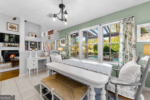 bedroom featuring light tile patterned floors, a notable chandelier, and a tile fireplace