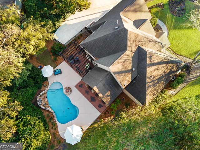 pool at dusk with outdoor lounge area and a patio