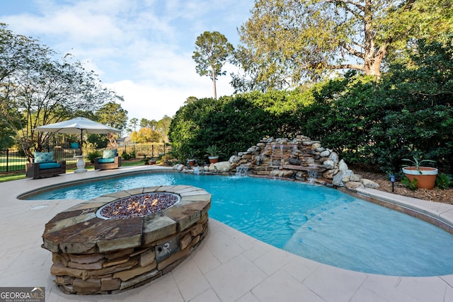 view of swimming pool featuring an outdoor fire pit and a patio