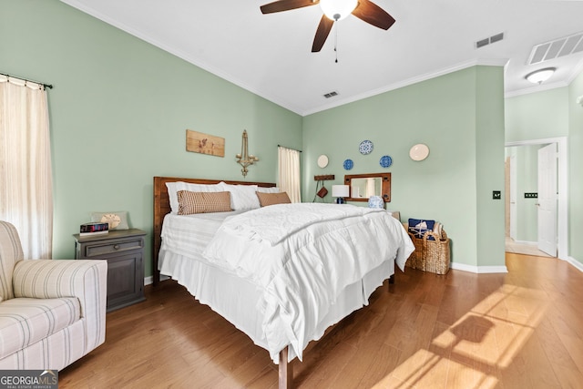 bedroom featuring hardwood / wood-style flooring, ceiling fan, and crown molding