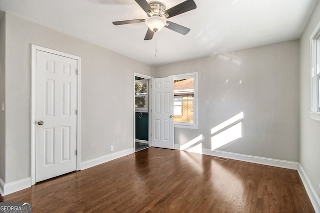 unfurnished bedroom featuring ceiling fan and dark hardwood / wood-style flooring