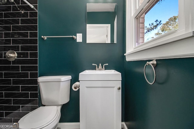 bathroom with vanity, toilet, and a tile shower