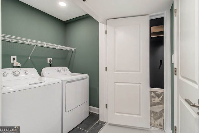 laundry area with washer and dryer and dark tile patterned floors