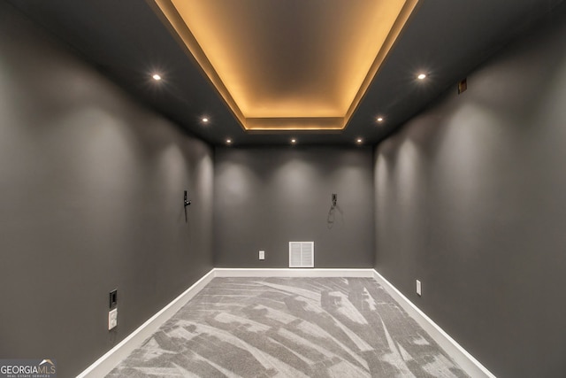 empty room featuring carpet and a raised ceiling