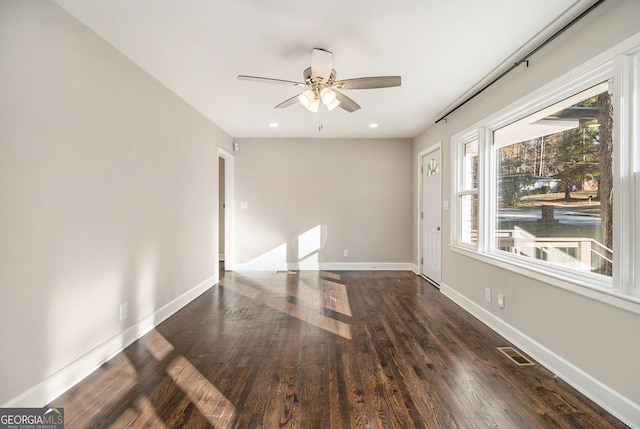 empty room featuring ceiling fan and dark wood-type flooring