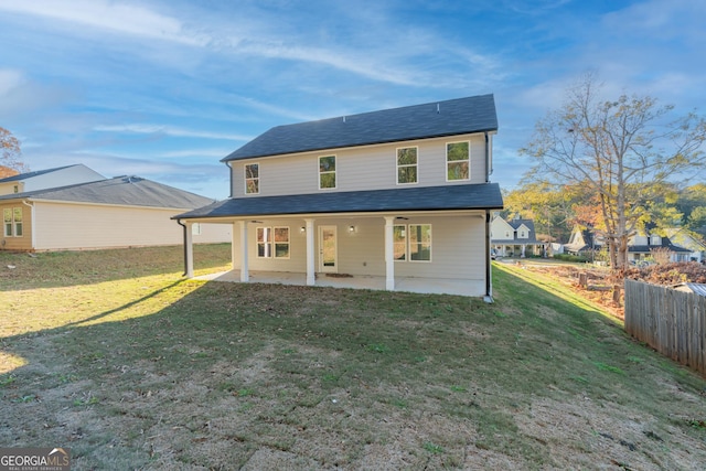 rear view of house with a yard, fence, and a patio