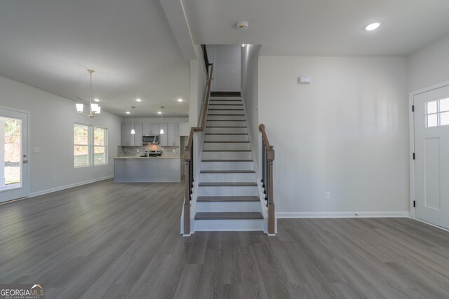 foyer featuring a chandelier, hardwood / wood-style floors, and a healthy amount of sunlight