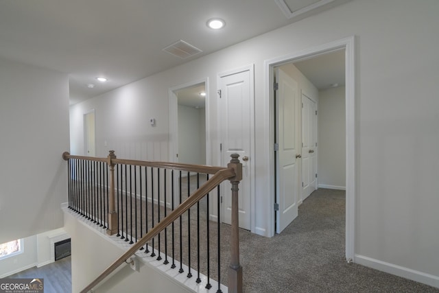 corridor with recessed lighting, visible vents, an upstairs landing, baseboards, and carpet