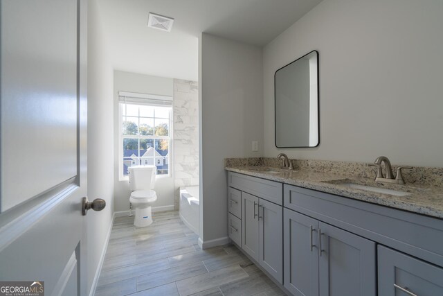 bathroom with vanity, hardwood / wood-style flooring, and toilet