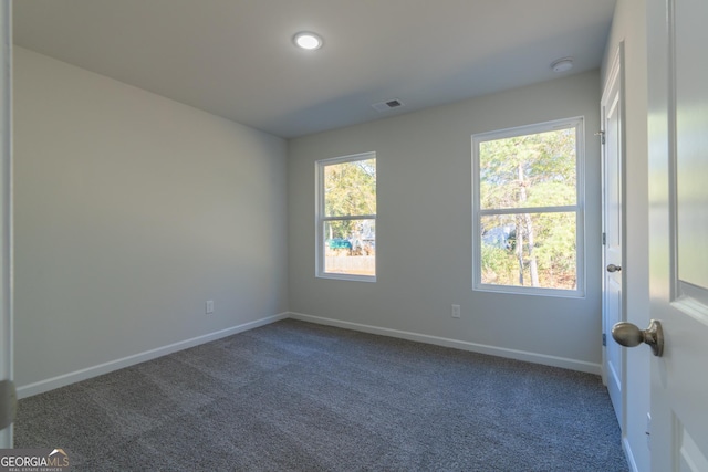 carpeted empty room with visible vents and baseboards