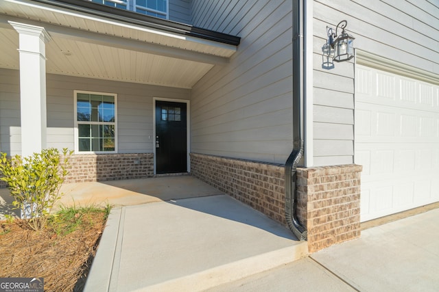 entrance to property with covered porch and a garage