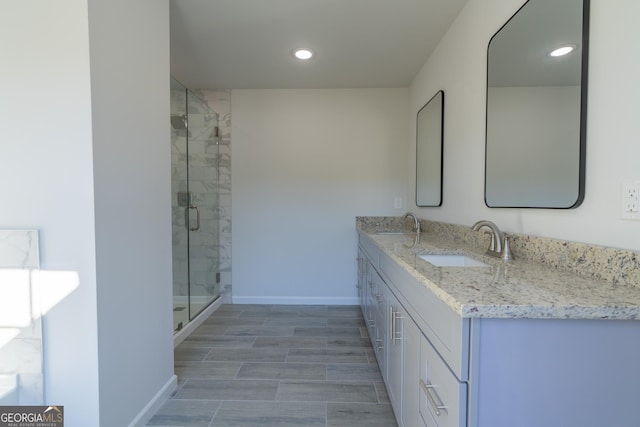 bathroom with a shower with door and vanity