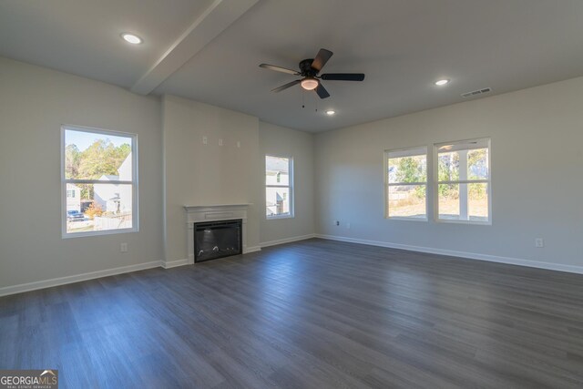 unfurnished living room featuring beamed ceiling, dark hardwood / wood-style flooring, and ceiling fan