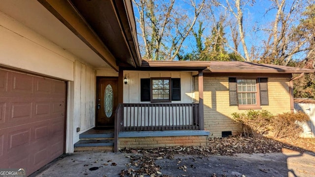 entrance to property with covered porch and a garage