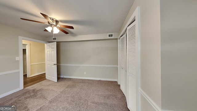 unfurnished bedroom featuring ceiling fan, light carpet, and a closet