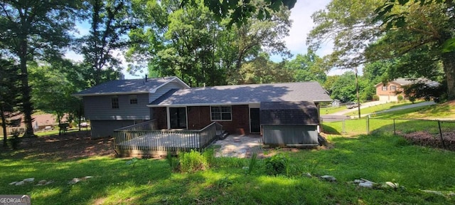 rear view of house with a deck and a lawn