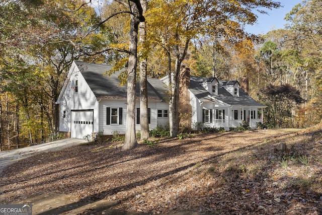 cape cod house featuring covered porch and a garage