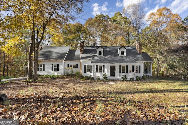 new england style home featuring a porch and a front yard